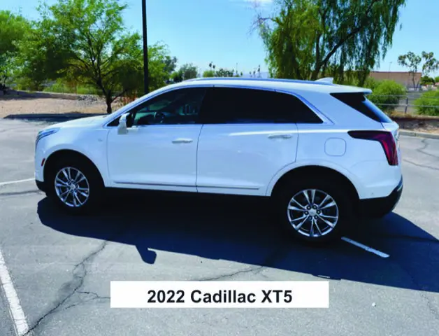 A white cadillac xt 5 parked in the parking lot.